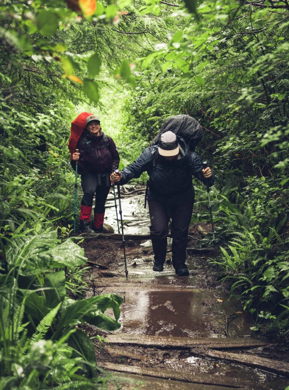 Backpackers navigating muddy forest trail