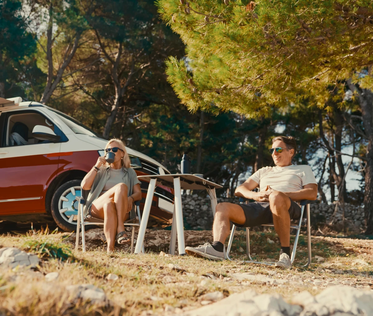 Couple relaxing by campervan in nature