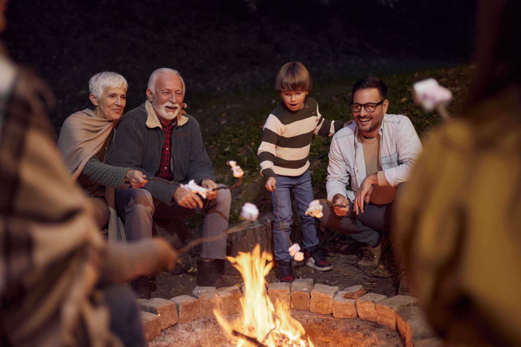 People enjoying marshmallows by a fire